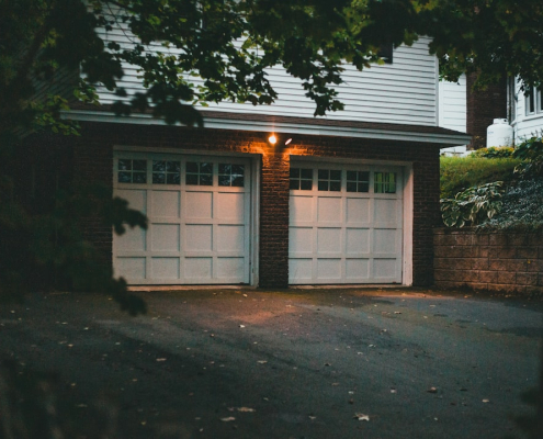 Double insulated garage doors on residential home exterior at dusk