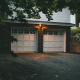 Double insulated garage doors on residential home exterior at dusk